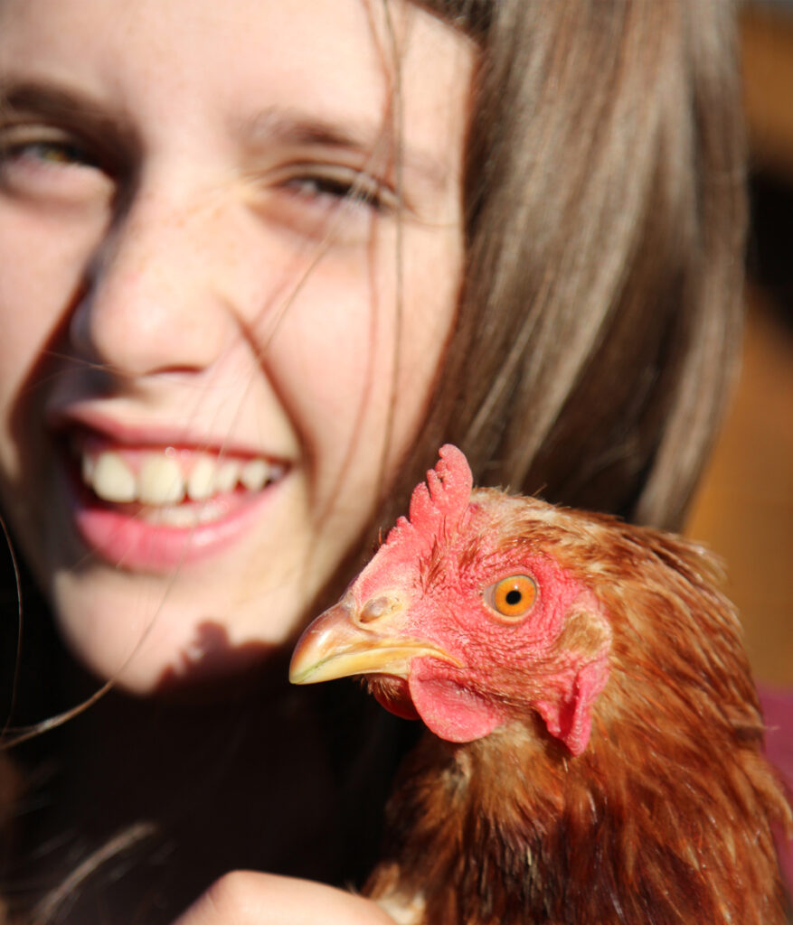 Kind hält Huhn im Arm
