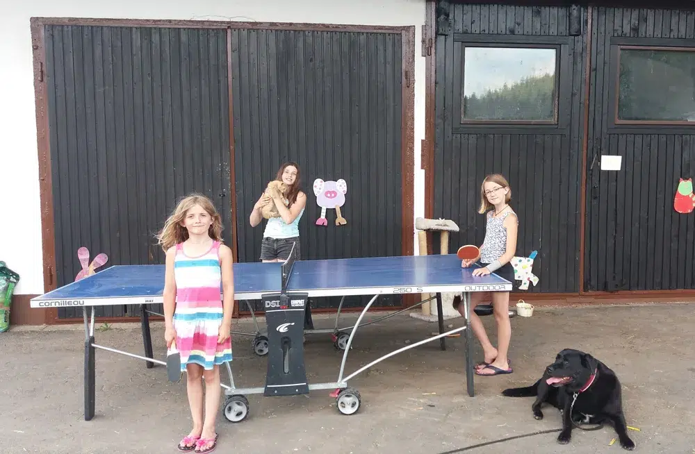 Kinder spielen Tischtennis auf dem Hof